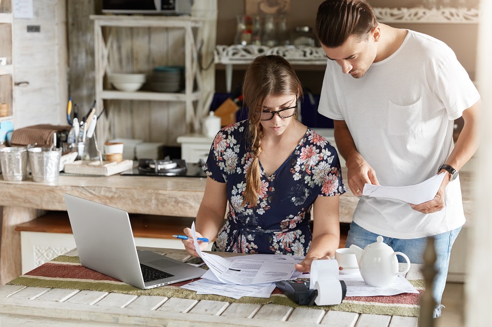 Young couple stressed out looking at bills online